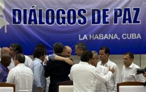 Miembros del equipo negociador del gobierno de Colombia, de la guerrilla de las FARC y observadores se abrazan después de la firma de un acuerdo de paz para buscar poner fin a más de 50 años de conflicto armado en la nación sudamericana. La firma se realizó en La Habana, Cuba, el miércoles 24 de agosto de 2016. (AP Foto/Ramon Espinosa)